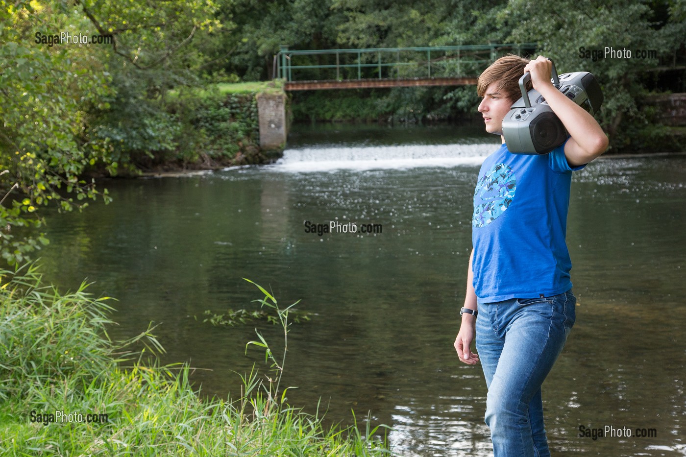 JEUNE ADOLESCENT QUI CHANTE ET ECOUTE DE LA MUSIQUE DANS LA NATURE, RUGLES (27), FRANCE 