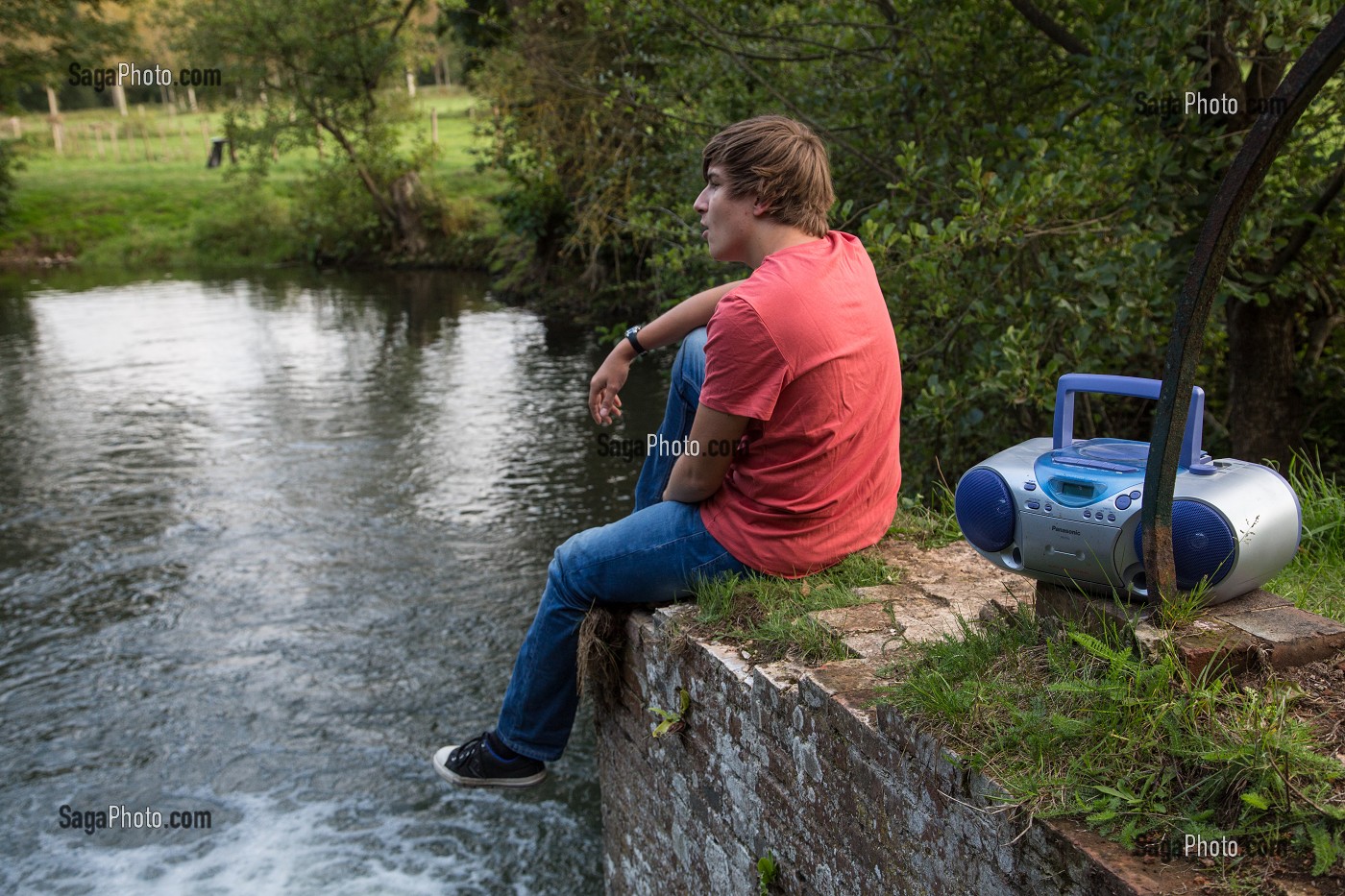 JEUNE ADOLESCENT QUI CHANTE ET ECOUTE DE LA MUSIQUE DANS LA NATURE, RUGLES (27), FRANCE 
