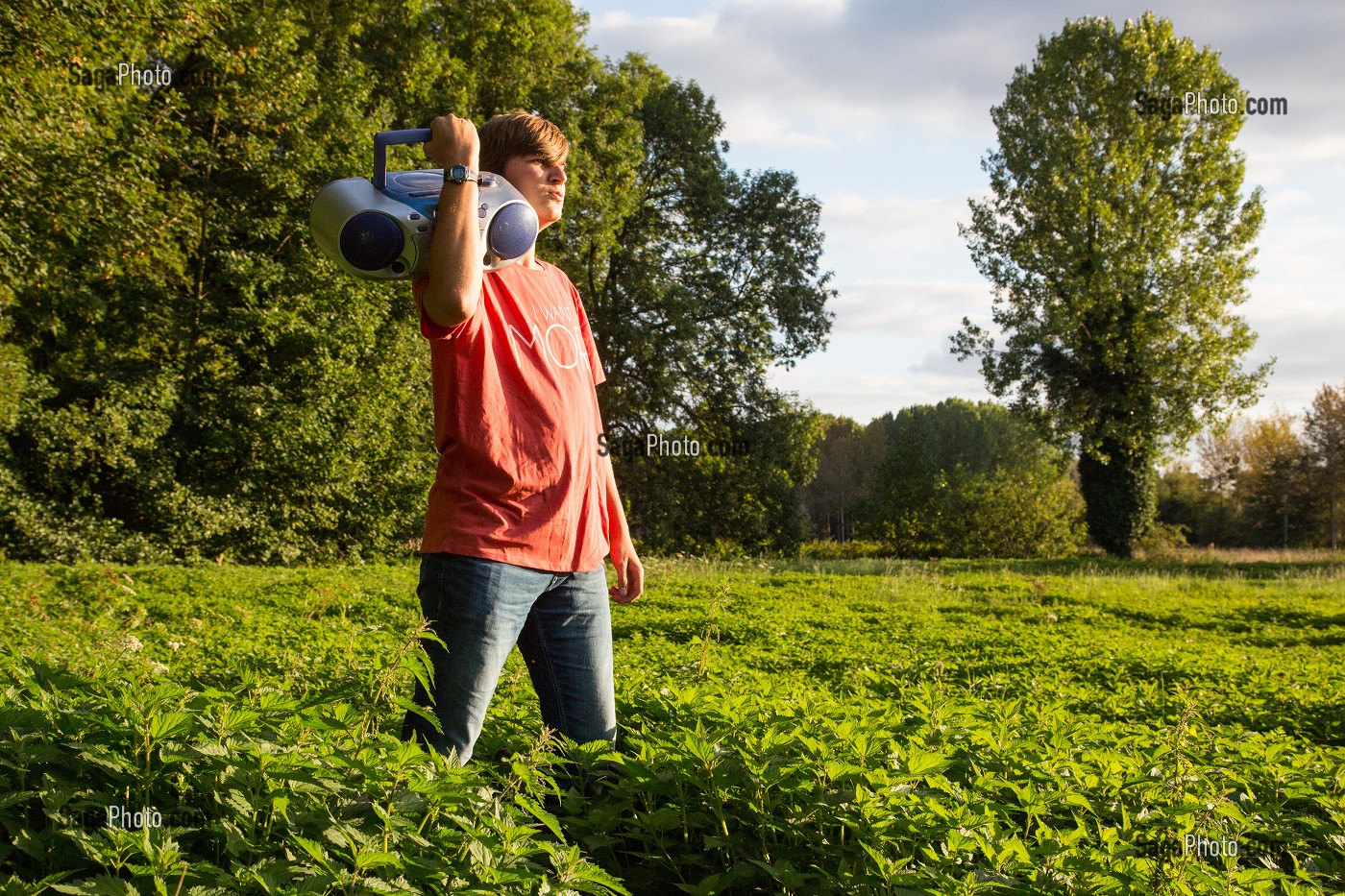 JEUNE ADOLESCENT QUI CHANTE ET ECOUTE DE LA MUSIQUE DANS LA NATURE, RUGLES (27), FRANCE 