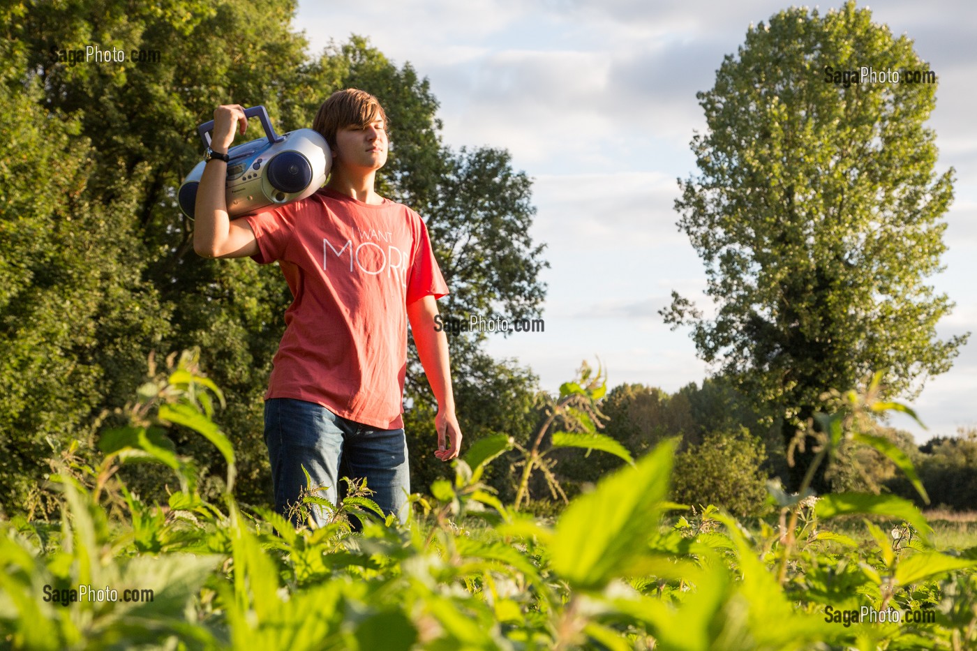 JEUNE ADOLESCENT QUI CHANTE ET ECOUTE DE LA MUSIQUE DANS LA NATURE, RUGLES (27), FRANCE 