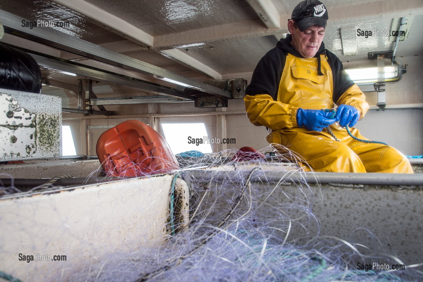 MARIN A LA REPARATION DU FILET, PECHE EN MER SUR LE FILEYEUR 'LES OCEANES' AU LARGE DE LORIENT (56), BRETAGNE, FRANCE 