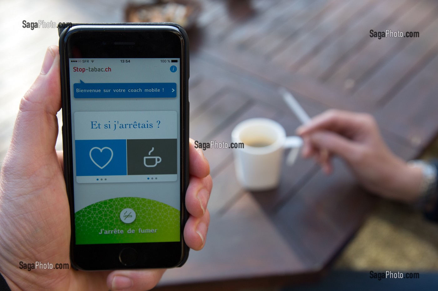 PERSONNE SUR SON TELEPHONE PORTABLE EN TRAIN DE CONSULTER UNE APPLICATION POUR AIDER A ARRETER DE FUMER, STOP-TABAC UN COACH MOBILE 