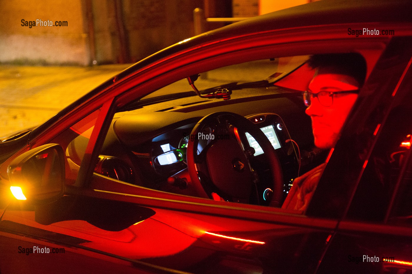 JEUNE HOMME AU VOLANT DE SA VOITURE A LA SORTIE DU CAFE (CAPITAINE DE SOIREE), CHAUFFEUR QUI ATTEND SES AMIS POUR LES RAMENER A LA MAISON, FRANCE 