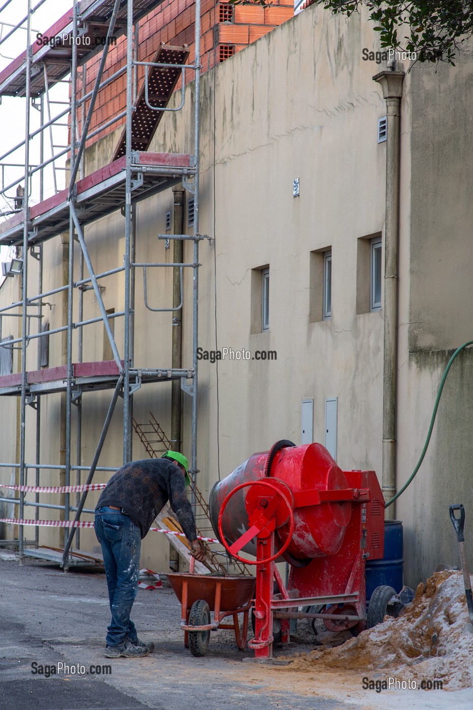 OUVRIER SUR UN RAVALEMENT DE FACADE AVEC SA BETONNEUSE, SANTA MARIA DE FEIRA, PORTUGAL 