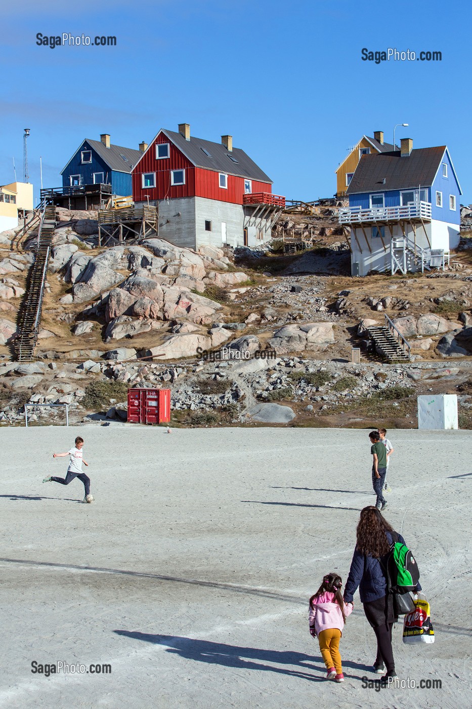 ENFANTS SUR LE TERRAIN DE FOOTBALL DEVANT LES MAISONS COLOREES, ILULISSAT, GROENLAND 