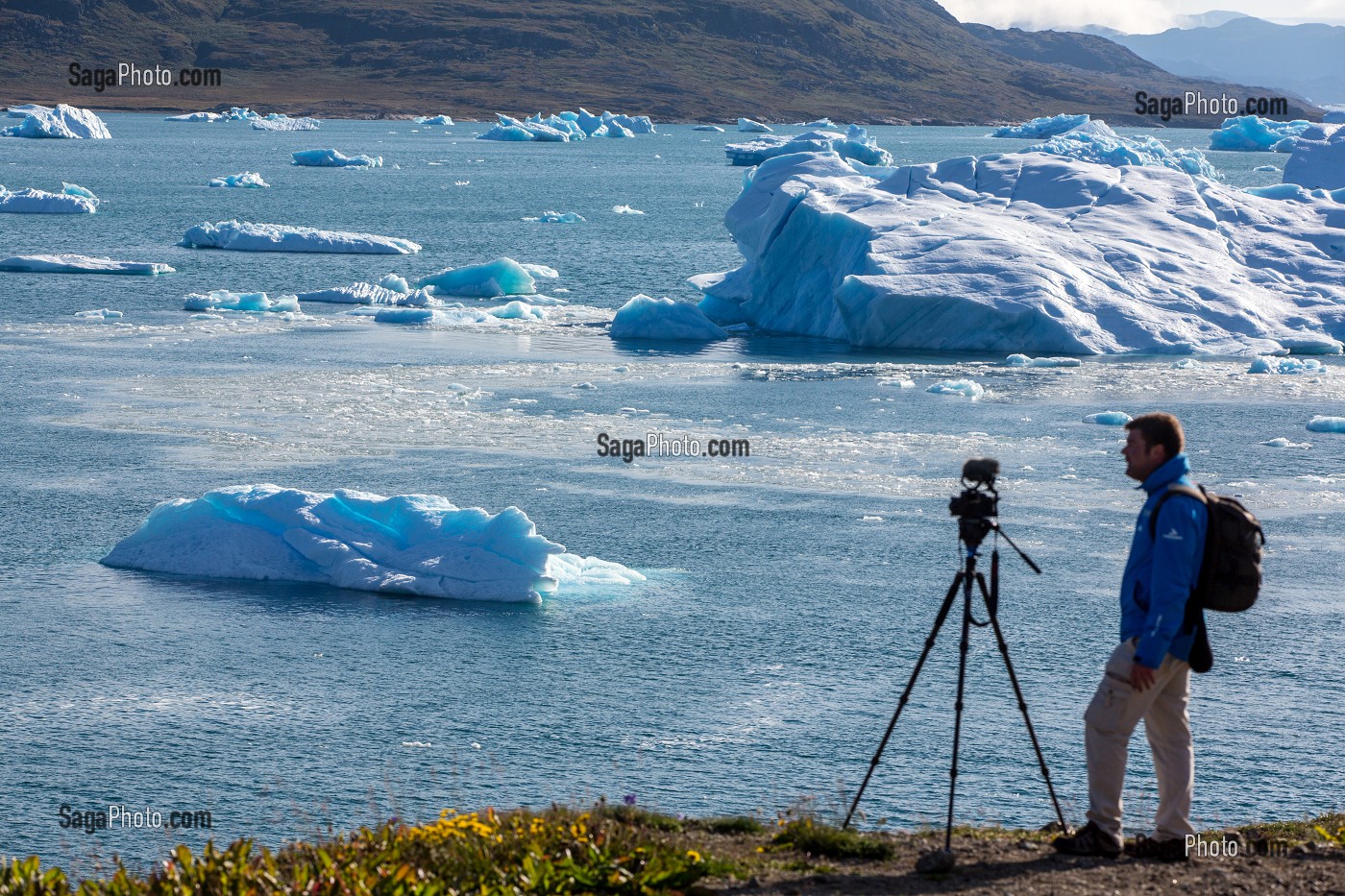 CAMERAMAN FILMANT LE SPECTACLE OFFERT PAR LES ICEBERGS FLOTTANT DANS LE FJORD DE LA BAIE DE NARSAQ, GROENLAND 