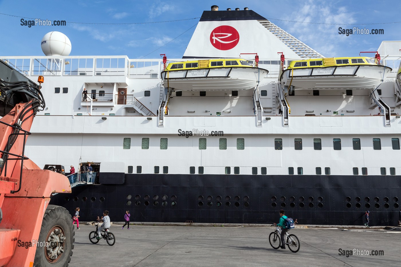 ENFANTS GROENLANDAIS A VELOS DEVANT LE PAQUEBOT A QUAI DANS LE PORT, BATEAU DE CROISIERE ASTORIA, NARSAQ, GROENLAND 