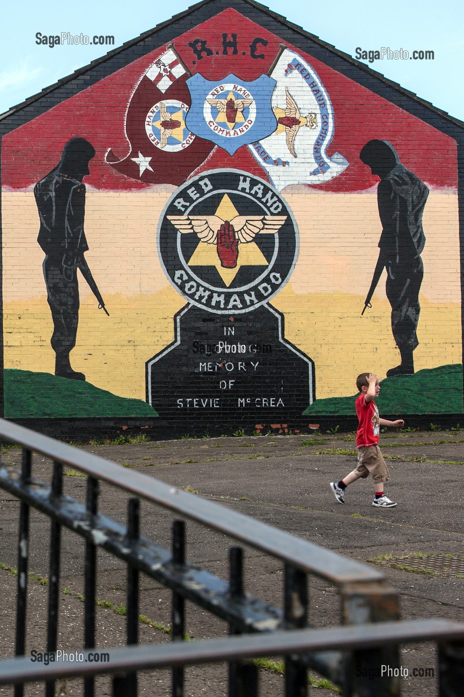 ENFANT DEVANT UNE FRESQUE MURALE (RHC, RED HAND COMMANDO), MUR DE MAISON DE SHANKILL ROAD, HOPEWELL AVENUE, QUARTIER OUEST PROTESTANT, BELFAST, ULSTER, IRLANDE DU NORD 