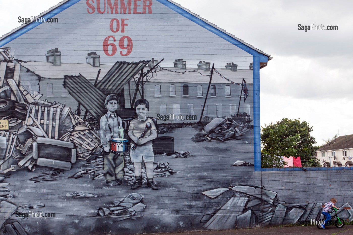 ENFANT A VELO, SOUVENIRS DES EMEUTES DU CONFLIT NORD IRLANDAIS A L'ETE 1969, SUMMER OF 69, FRESQUES MURALES SUR LES MURS DES MAISONS DE SHANKILL ROAD, HOPEWELL AVENUE, QUARTIER OUEST PROTESTANT, BELFAST, ULSTER, IRLANDE DU NORD 