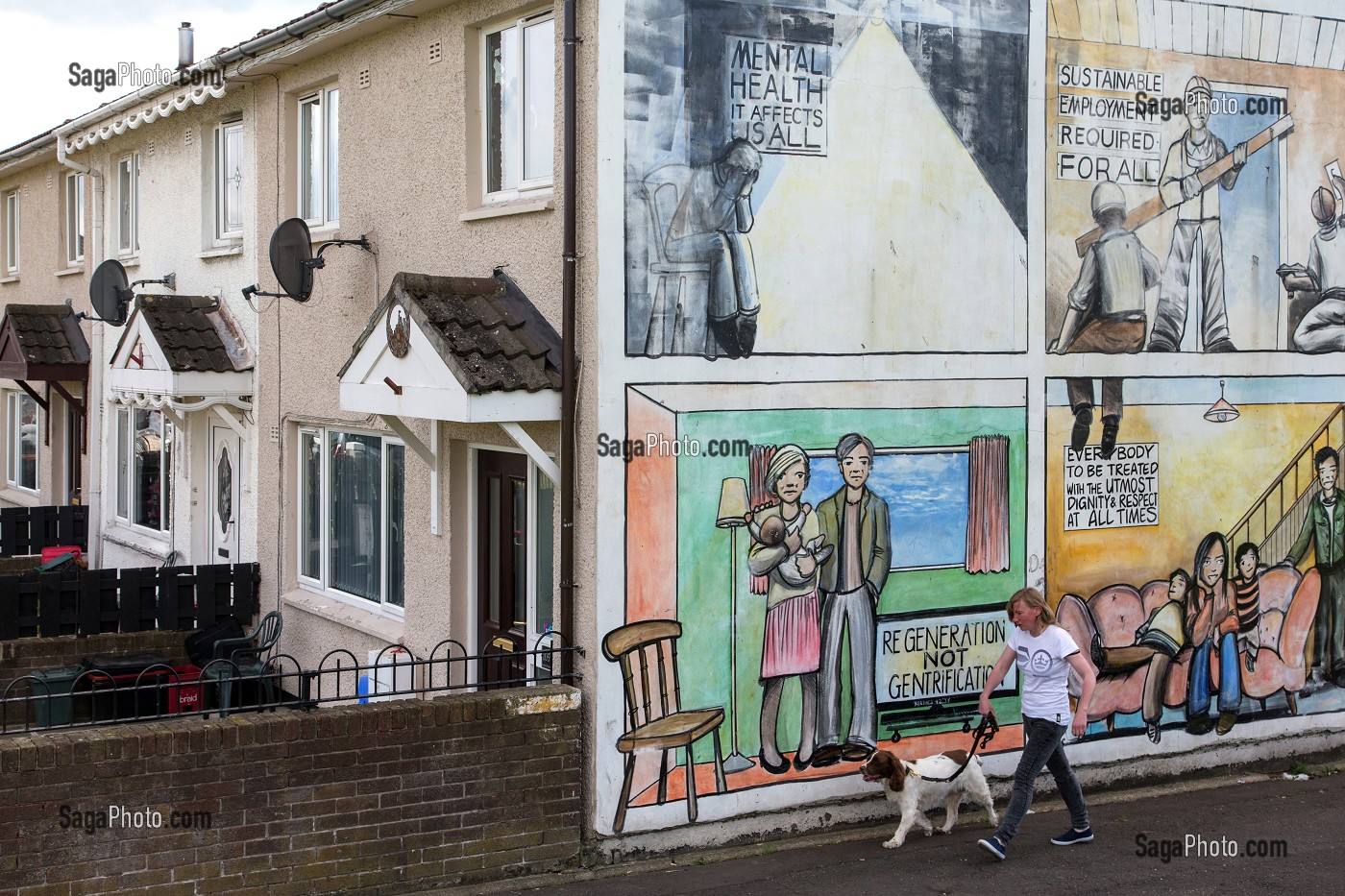 JEUNE HOMME AVEC SON CHIEN DEVANT LES FRESQUES MURALES SUR LES MURS DES MAISONS DE SHANKILL ROAD, HOPEWELL SQUARE, QUARTIER OUEST PROTESTANT, BELFAST, ULSTER, IRLANDE DU NORD 