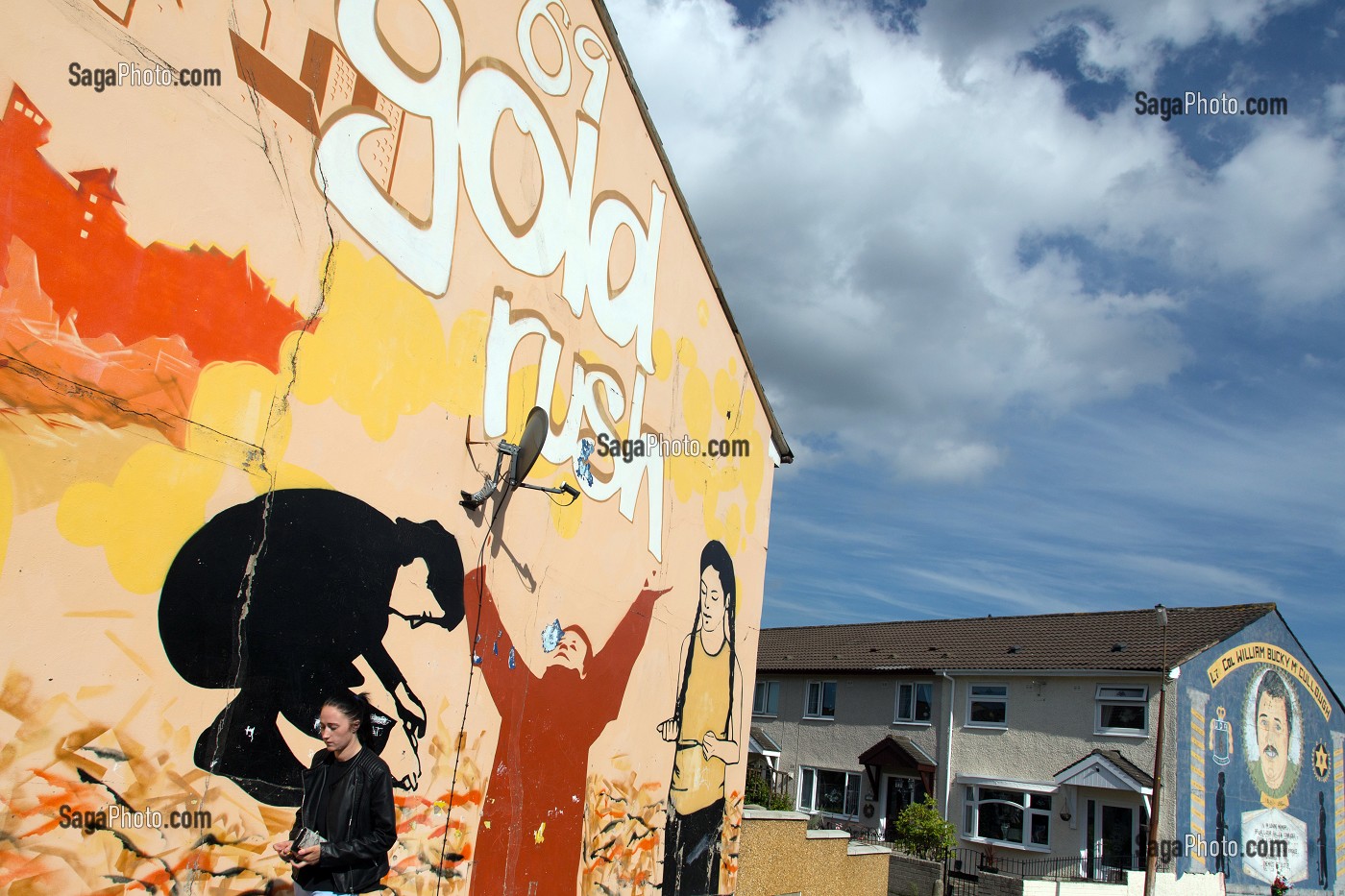 FEMME DEVANT LES FRESQUES MURALES SUR LES MURS DES MAISONS DE SHANKILL ROAD, HOPEWELL CRESCENT, QUARTIER OUEST PROTESTANT, BELFAST, ULSTER, IRLANDE DU NORD 