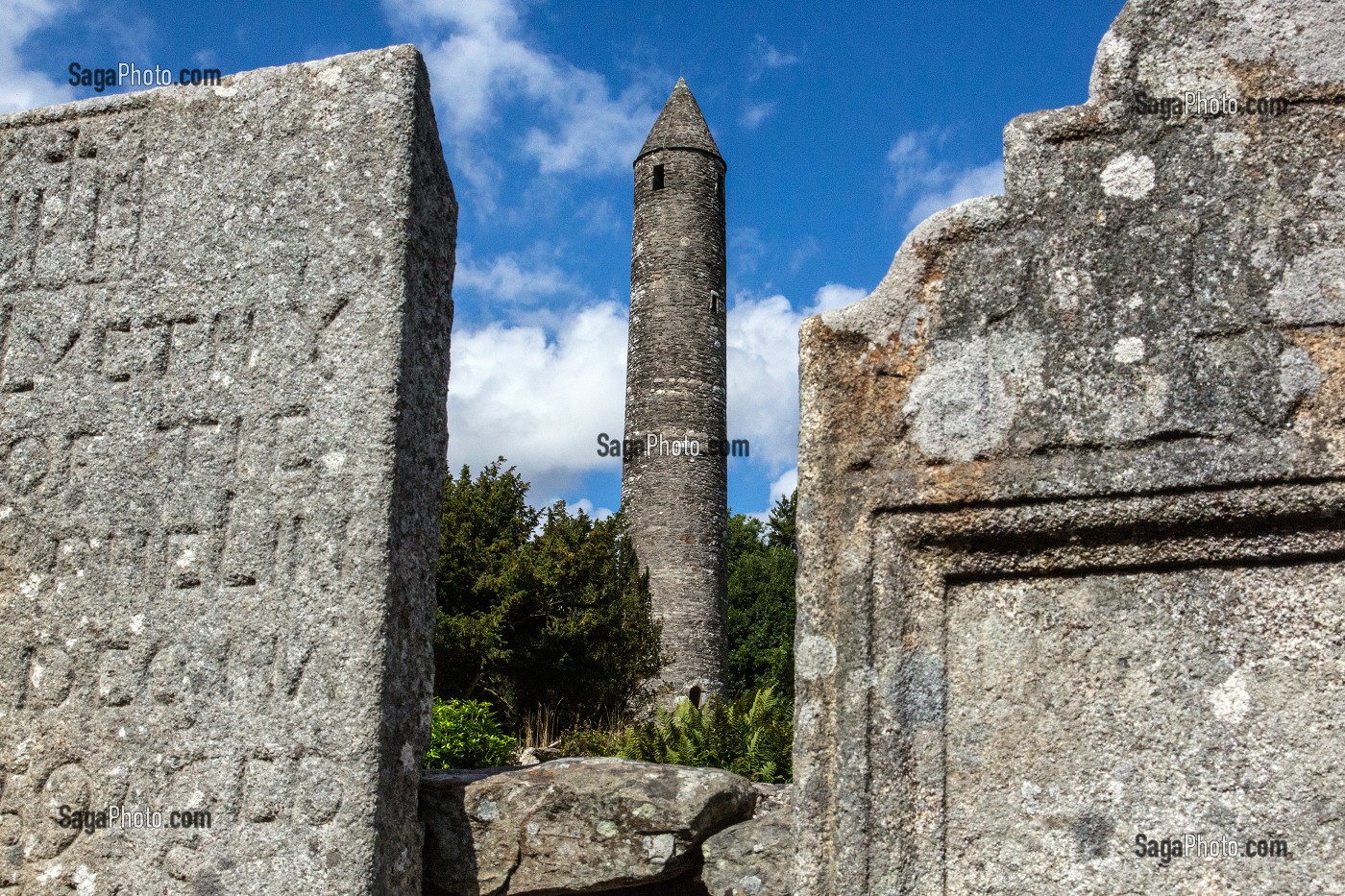 PIERRES TOMBALES DEVANT LA TOUR RONDE HAUTE DE 33 METRES RUINES DE L'ANCIEN MONASTERE DE GLENDALOUGH ETABLI AU VI EME SIECLE DETRUIT EN 1398 PAR LES ANGLAIS, COMTE DE WICKLOW, IRLANDE 