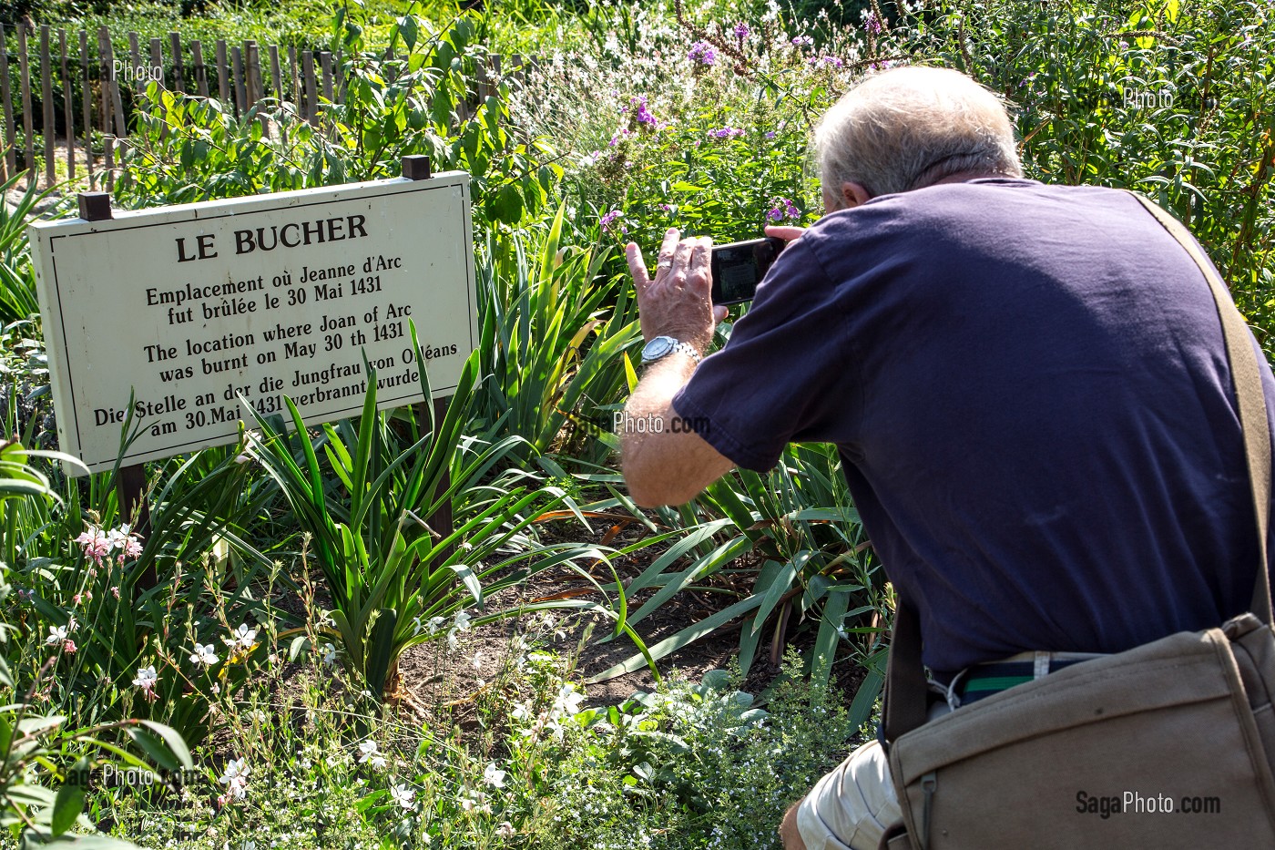 TOURISTE QUI PHOTOGRAPHIE LA PLAQUE COMMEMORATIVE DU BUCHER, EMPLACEMENT OU FUT BRULEE JEANNE D'ARC LE 30 MAI 1431, ROUEN (76), FRANCE 