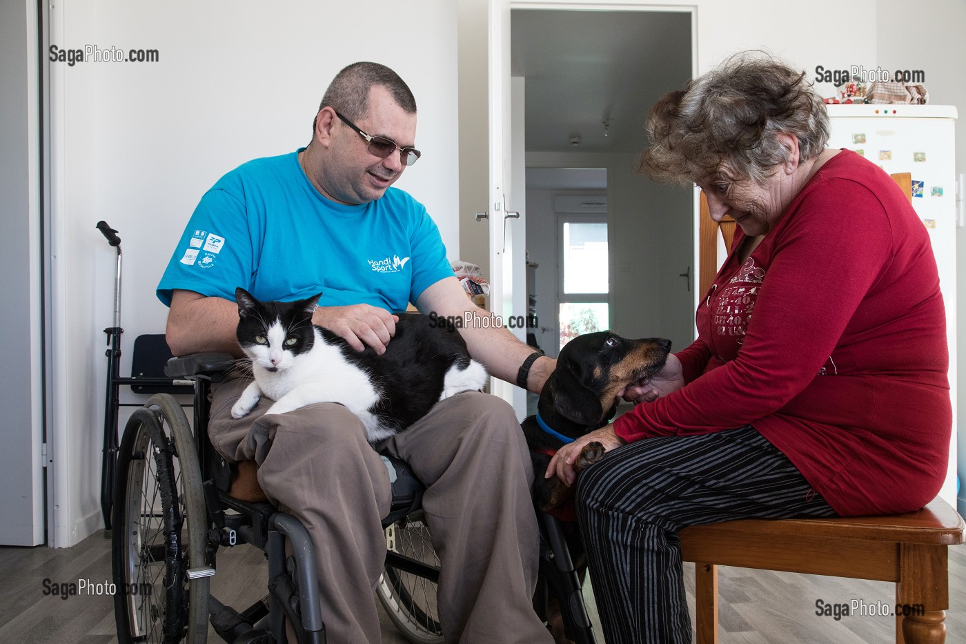 HOMME HANDICAPE PHYSIQUE DANS SON FAUTEUIL ROULANT AVEC SA FEMME AVEC SON CHAT ET SON CHIEN, CHARTRES (28), FRANCE 