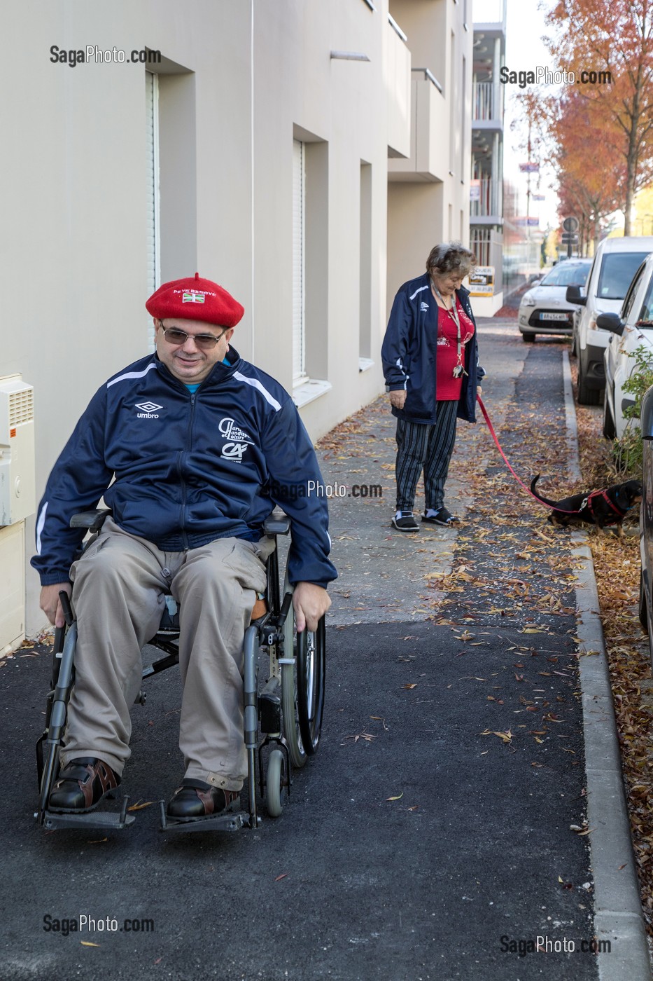 HOMME HANDICAPE PHYSIQUE DANS SON FAUTEUIL ROULANT SUR LE TROTTOIR, CHARTRES (28), FRANCE 