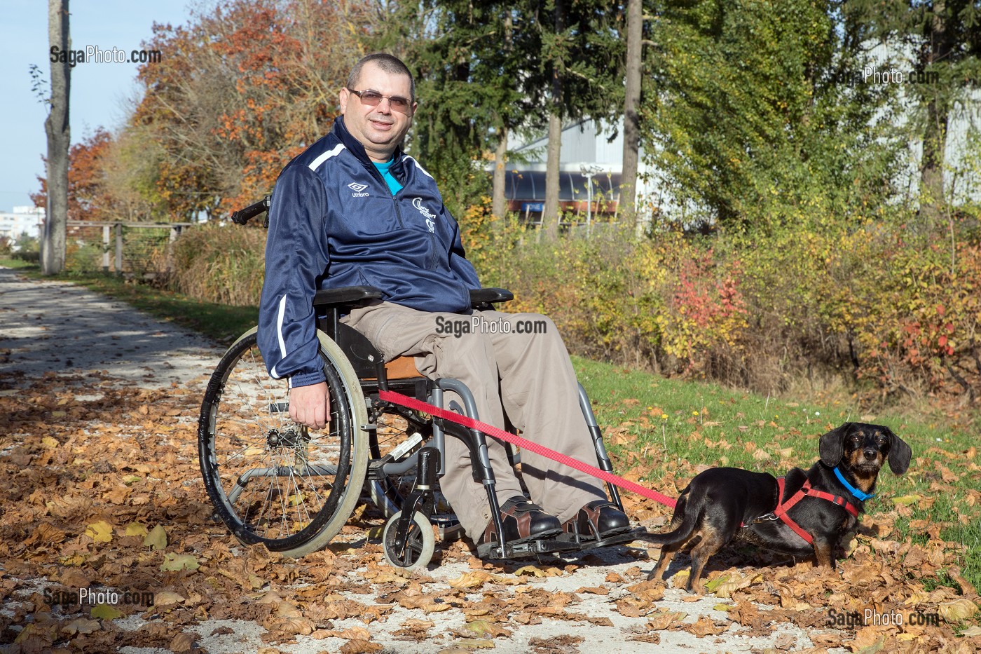 HOMME HANDICAPE PHYSIQUE DANS SON FAUTEUIL ROULANT EN BALADE DANS LE PARC AVEC SON CHIEN, CHARTRES (28), FRANCE 