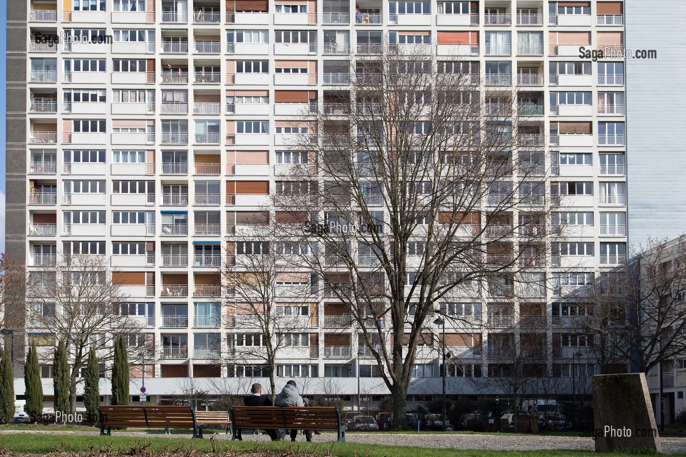 PERSONNES ASSISES SUR UN BANC DEVANT LEUR CITE HLM, RENNES (35), FRANCE 