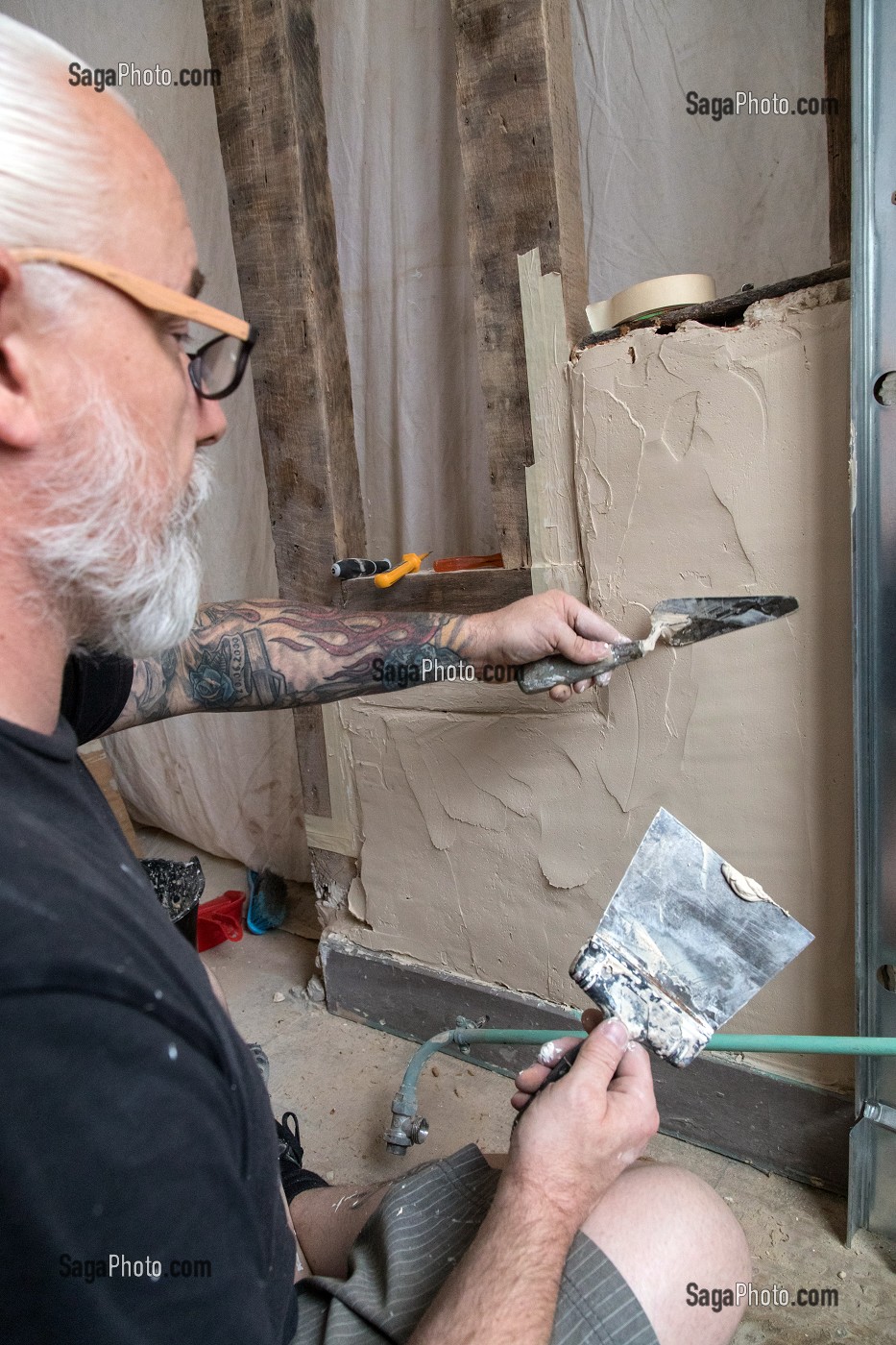 OUVRIER SUR UN CHANTIER DE RESTAURATION, (COLLE, CIMENT, MAP), TRAVAUX D'AMENAGEMENT INTERIEUR, RENOVATION D'UNE MAISON 
