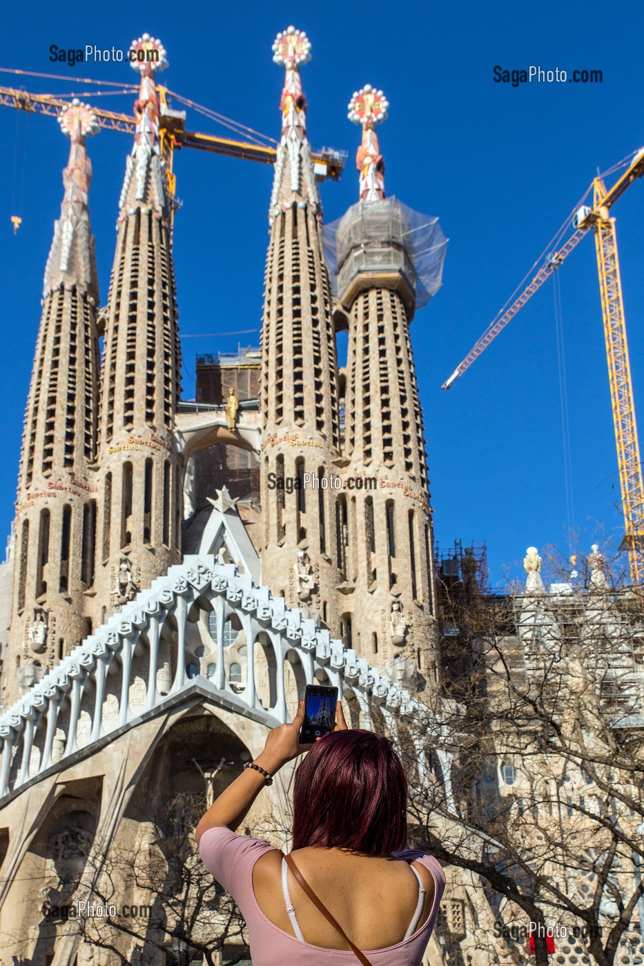 FEMME PHOTOGRAPHIANT LA FACADE BASILIQUE LA SAGRADA FAMILIA AVEC SON SMARTPHONE, TEMPLE EXPIATORI, BARCELONE, CATALOGNE, ESPAGNE 