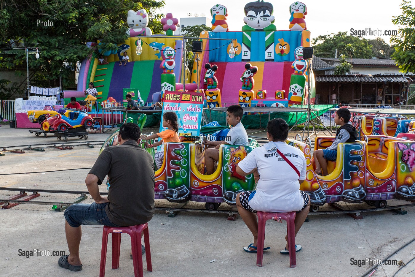 ENFANTS JOUANT DANS UN MANEGE SUR UNE PLACE, BANG SAPHAN, PROVINCE DE PRACHUAP KHIRI KHAN, THAILANDE 