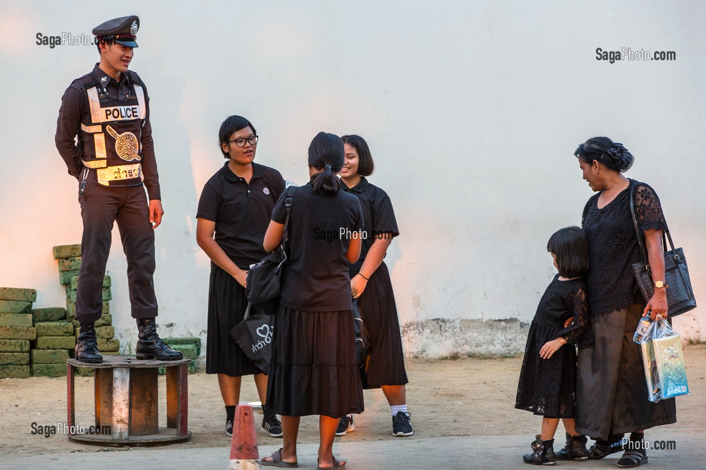 POLICIER DISCUTANT AVEC DES PASSANTS DANS LA RUE, BANGKOK, THAILANDE 