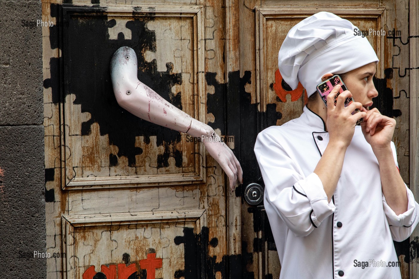 CUISINIERE DEVANT LA PORTE DE SON RESTAURANT, STREET-ART DANS LES RUE DE FUNCHAL, GRAFFITIS SUR LA FACADE DES MAISONS, FUNCHAL, ILE DE MADERE, PORTUGAL 