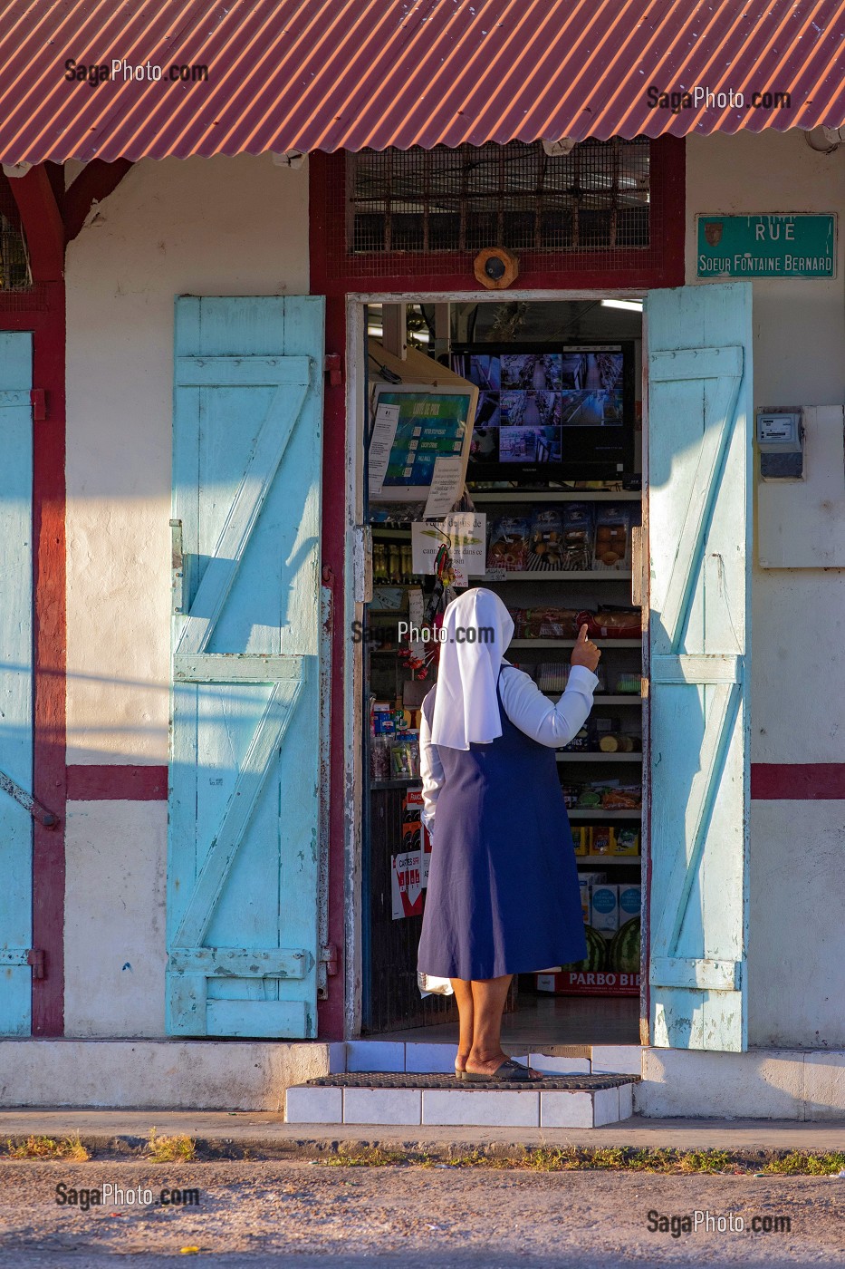 UNE SOEUR DEVANT LA PORTE DE L'EPICERIE DU VILLAGE, MANA, GUYANE FRANCAISE, DEPARTEMENT-REGION D'OUTRE-MER, AMERIQUE DU SUD, FRANCE 