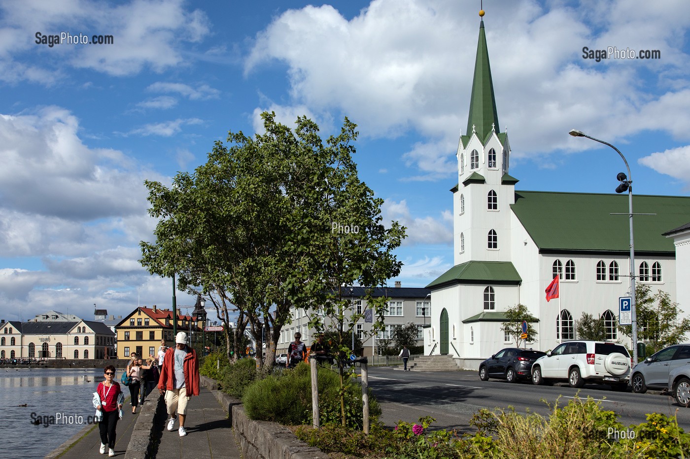 PROMENEUR AU BORD DU LAKE TJORNIN DEVANT L'EGLISE FRIKIRKJAN, REYKJAVIK, ISLANDE 