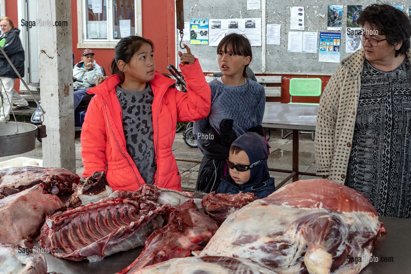 FAMILLE DEVANT UN ETAL DE BOEUF MUSQUE AU MARCHE AU VIANDE, VILLE DE QAQORTOQ, GROENLAND, DANEMARK 