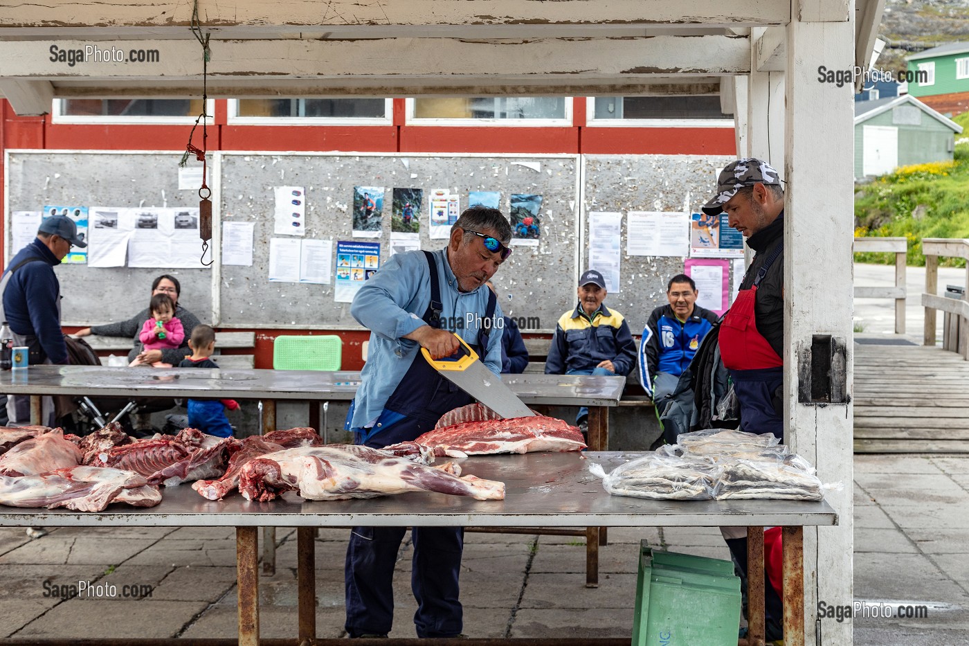 BOUCHER DECOUPANT DES CARCASSES DE BOEUF MUSQUE AU MARCHE AU VIANDE, VILLE DE QAQORTOQ, GROENLAND, DANEMARK 