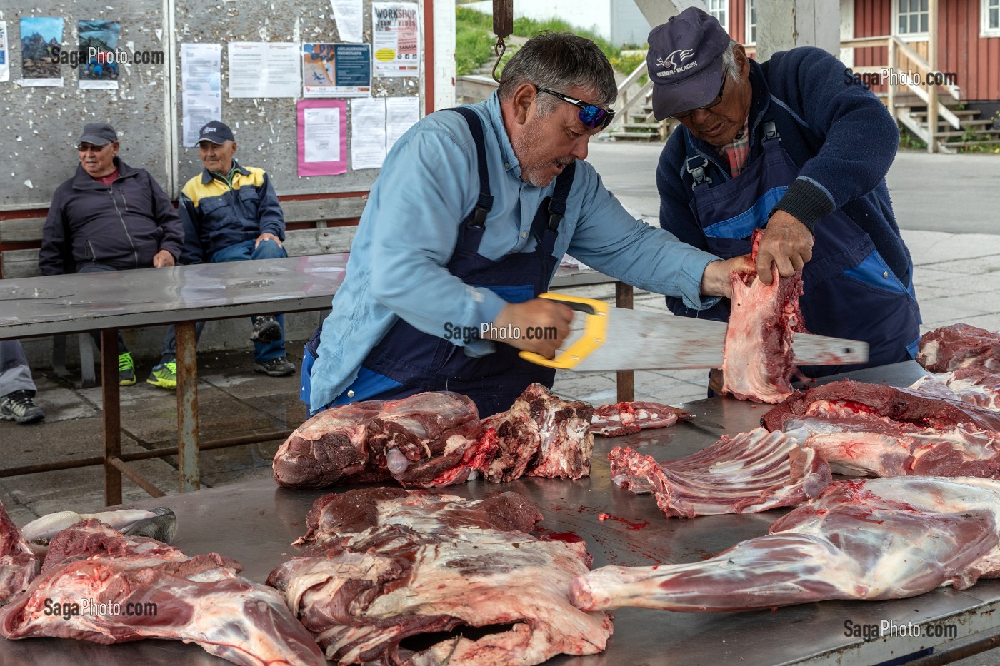 BOUCHER DECOUPANT DES CARCASSES DE BOEUF MUSQUE ET DE RENES, MARCHE A LA VIANDE, VILLE DE QAQORTOQ, GROENLAND, DANEMARK 