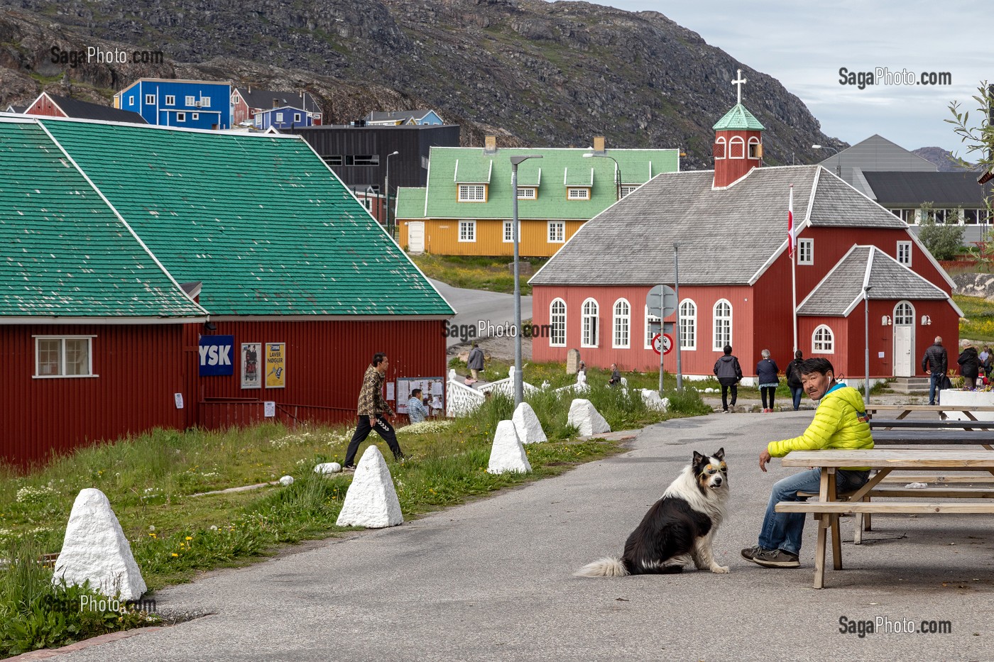 HOMME ASSIS SUR UN BANC AVEC SON CHIEN PORTANT UNE PAIRE DE LUNETTES DE SOLEIL DEVANT L'EGLISE DOWNLOAD, VILLE DE QAQORTOQ, GROENLAND, DANEMARK 