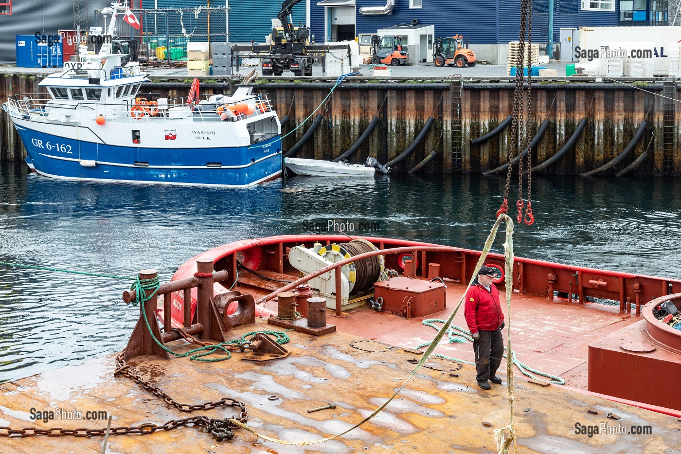 HOMME SUR UN PONT DE BATEAU DEVANT LE BATEAU PAARNAQ, PORT DE NUUK, GROENLAND, DANEMARK 