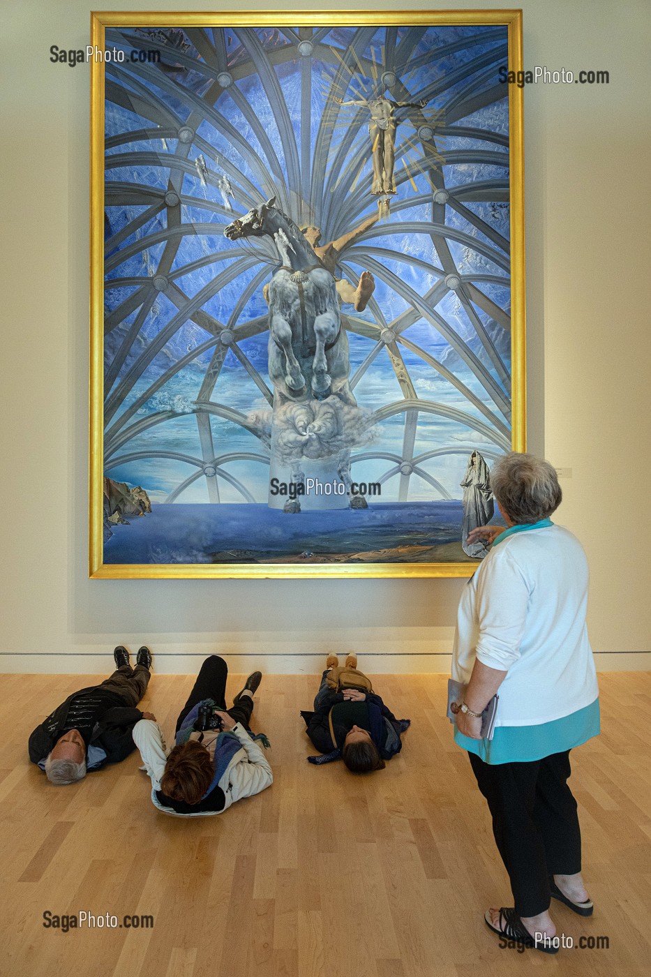 VISITEURS ALLONGES DEVANT LE TABLEAU, SANTIAGO EL GRANDE, SALVADOR DALI, REPRESENTATION MONUMENTALE DE L'APOTRE SAINT-JACQUES, GALERIE D'ART BEAVERBROOK, FREDERICTON, NOUVEAU-BRUNSWICK, CANADA 