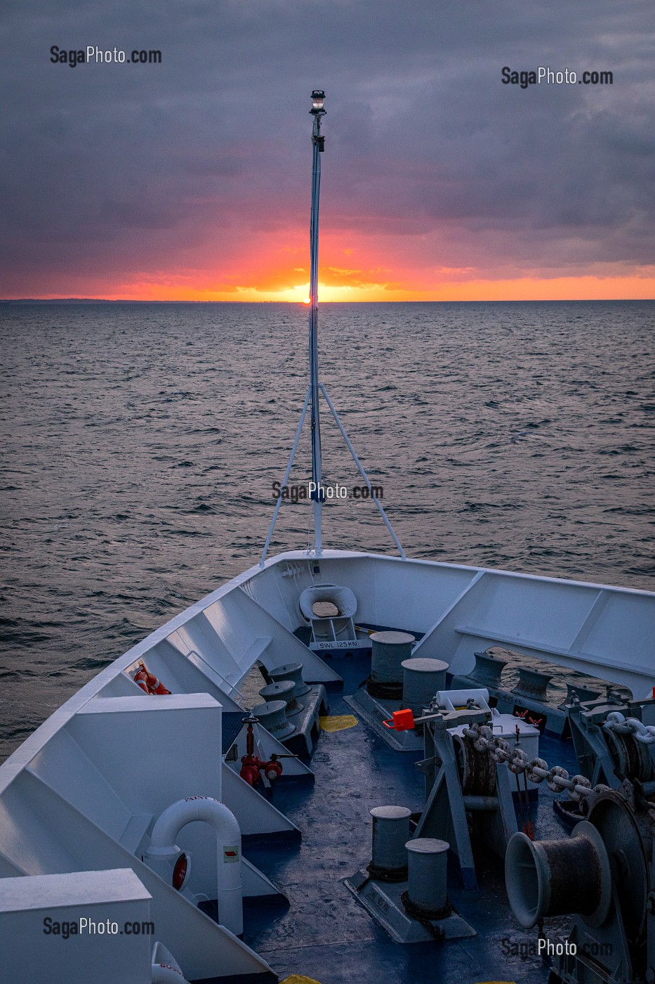 PROUE D'UN BATEAU DE CROISIERE AU COUCHER DE SOLEIL SOUS UN CIEL D'ORAGE AU LARGE DE DUNKERQUE SUR LA MANCHE, FRANCE 