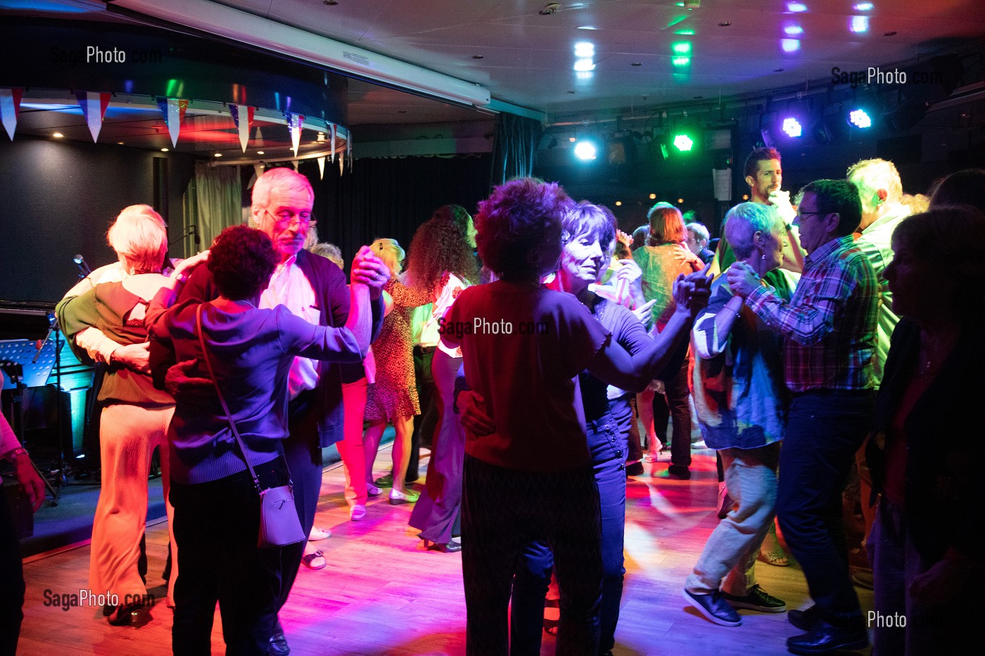 AMBIANCE FESTIVE AVEC UN PUBLIC INTERGENERATIONNEL (JEUNES ET SENIORS), MUSIQUE ET DANSE SUR LA PISTE DE LA SALLE DE SPECTACLE SUR UN BATEAU DE CROISIERE 