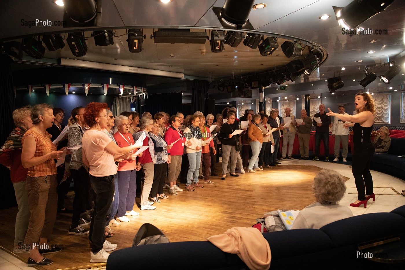 CHORALE AVEC UNE CHANTEUSE ET LES PASSAGERS A BORD D'UN BATEAU DE CROISIERE 