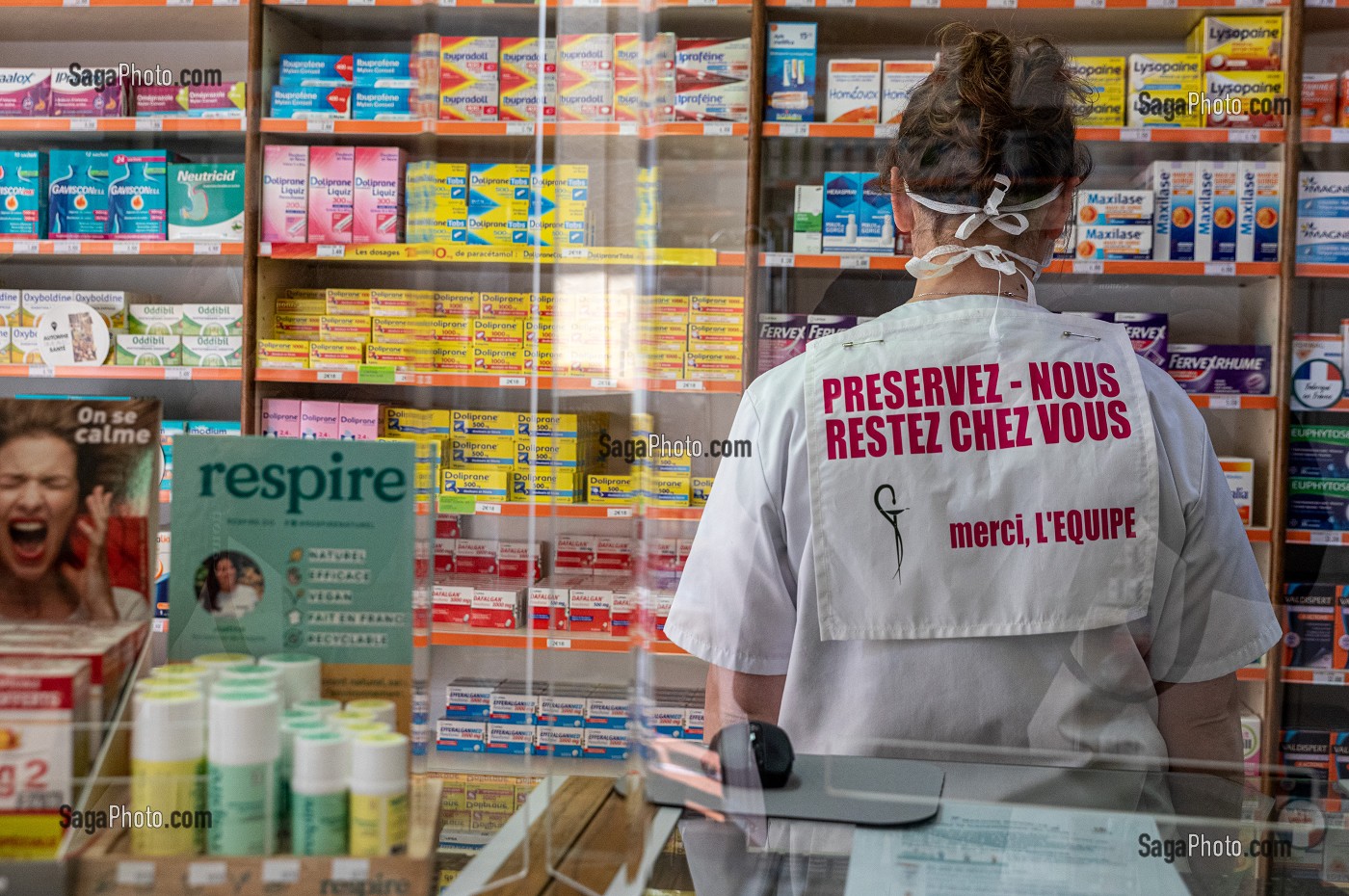 PRESERVEZ-NOUS, RESTEZ CHEZ VOUS, EMPLOYE DE LA PHARMACIE DERRIERE DES VITRES DE PROTECTION EN PLEXIGLASS, MESURES SANITAIRES DE PREVENTION SUITE A L'EPIDEMIE DE CORONAVIRUS, RUGLES, NORMANDIE, FRANCE 