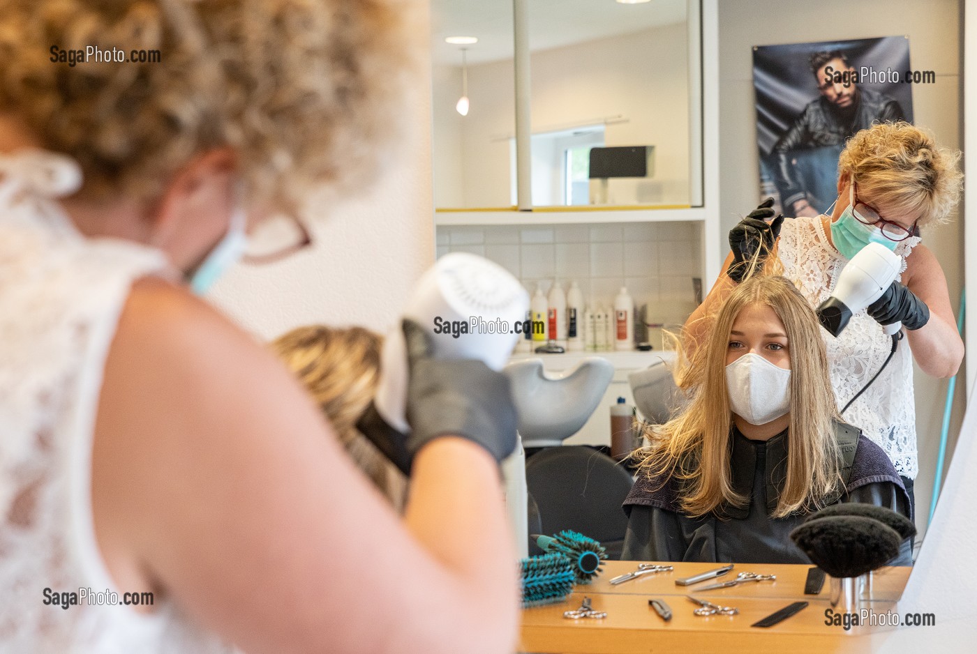 SECHAGE DES CHEVEUX, COIFFEUSE AVEC SON MASQUE DE PROTECTION ET SES GANTS EN TRAIN DE COIFFER UNE CLIENTE DANS LE SALON DE COIFFURE VIDE, RUGLES, NORMANDIE, FRANCE 