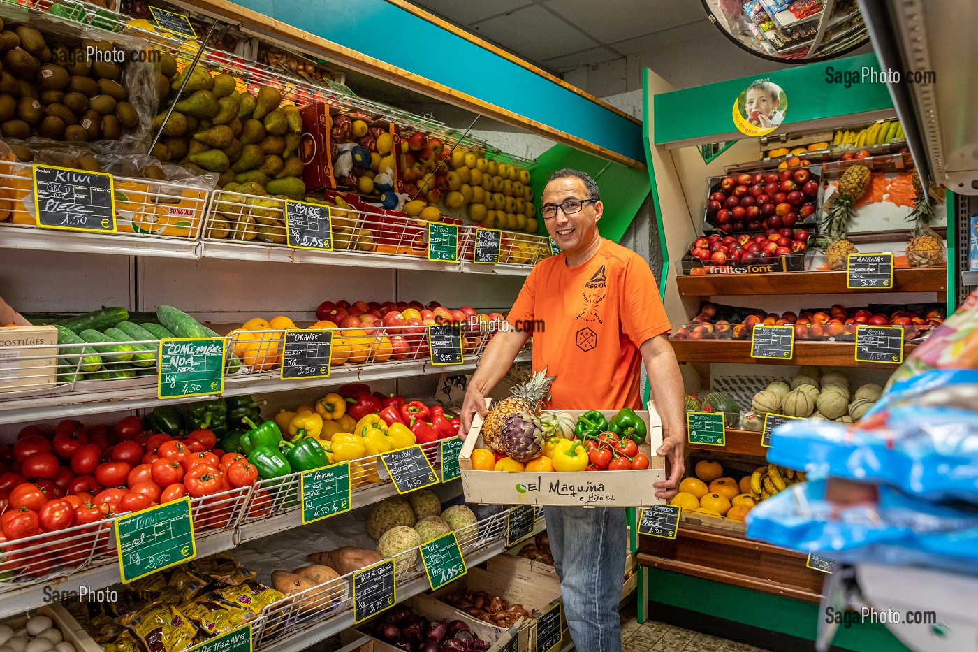 HASSAN DANS SON EPICERIE ENTOURE PAR SES FRUITS ET LEGUMES, RUGLES, EURE, NORMANDIE, FRANCE, EUROPE 