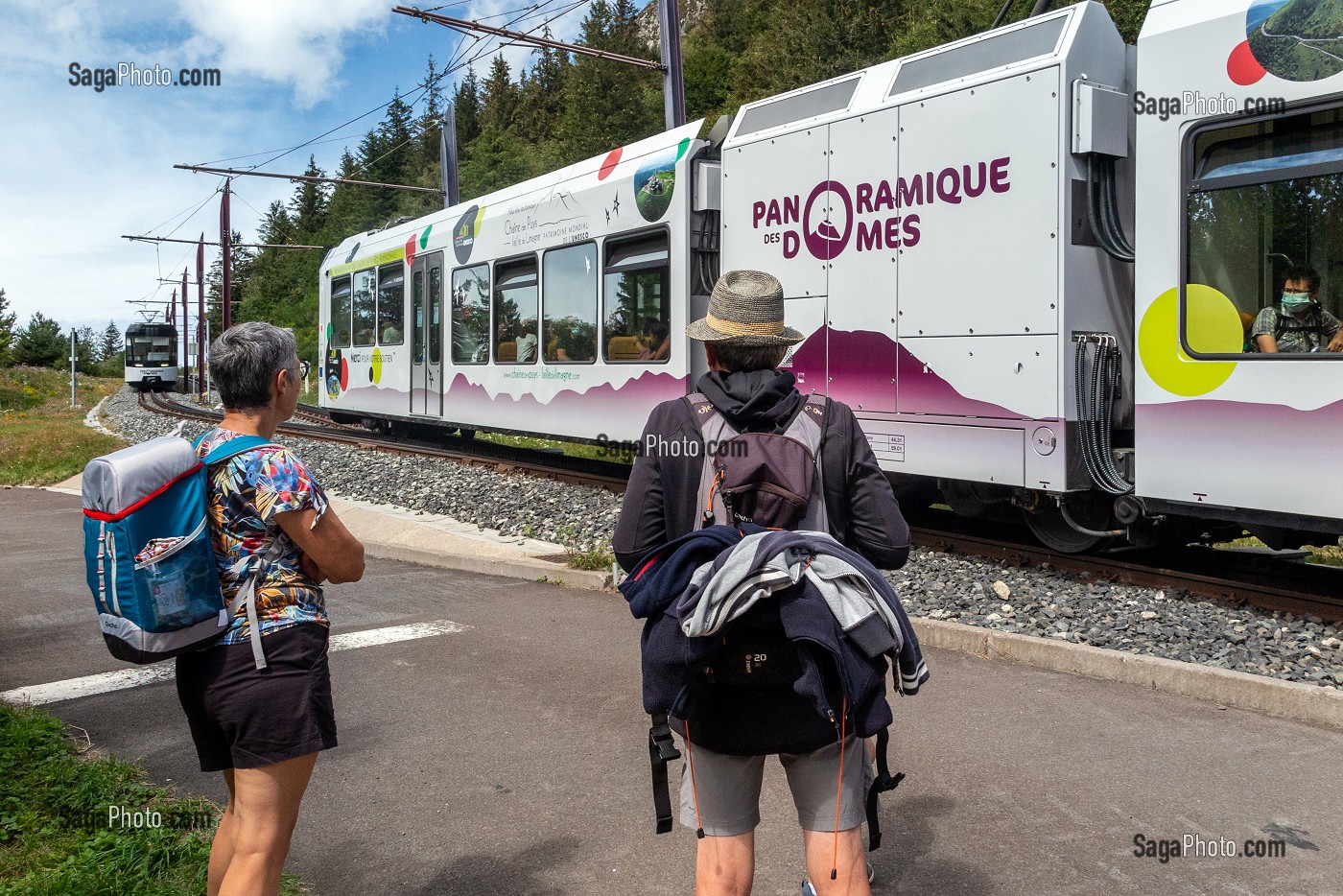 RANDONNEURS A PIED DEVANT LE TRAIN PANORAMIQUE DES DOMES VERS LE SOMMET DU PUY-DE-DOME, VOLCAN D'AUVERGNE, ORCINES, FRANCE 