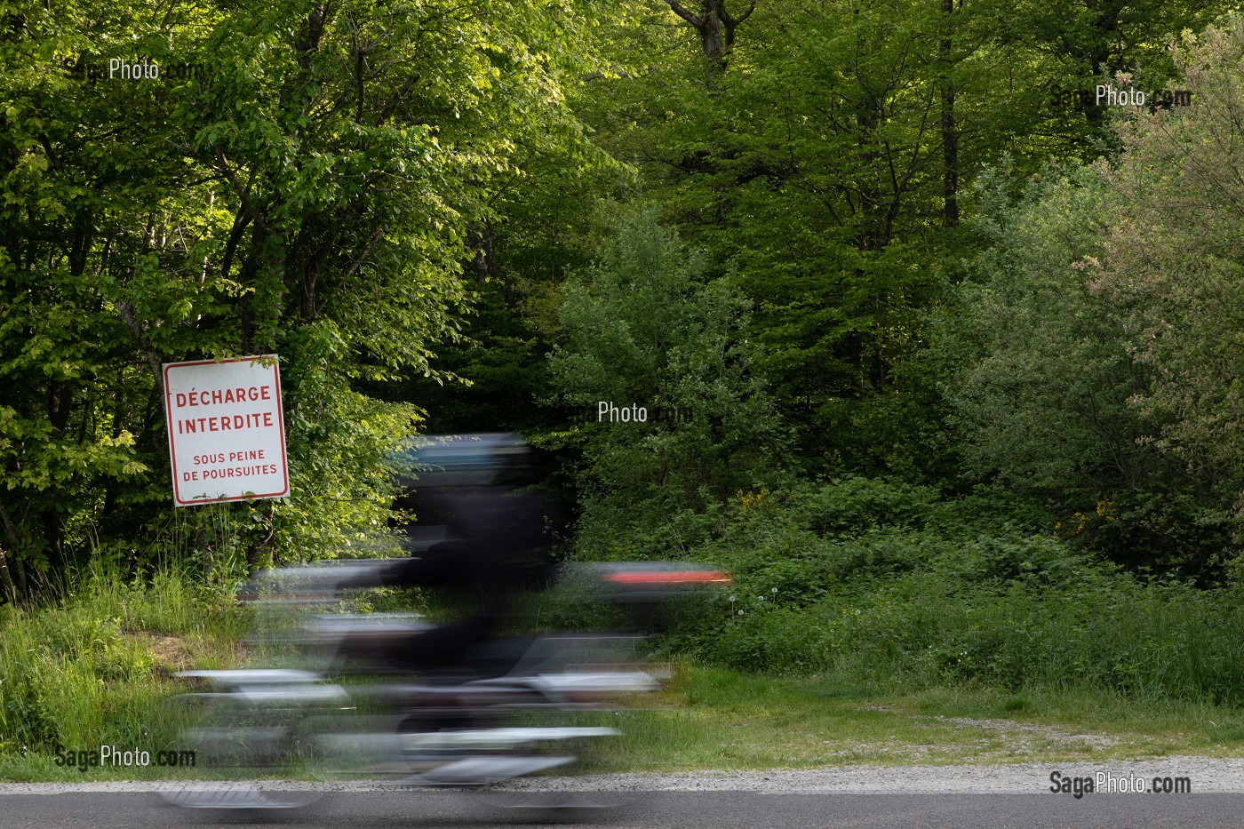 MOTO DEVANT LA FORET AVEC UN PANNEAU DE DECHARGE INTERDITE SOUS PEINE DE POURSUITES, RUGLES, EURE, NORMANDIE, FRANCE 