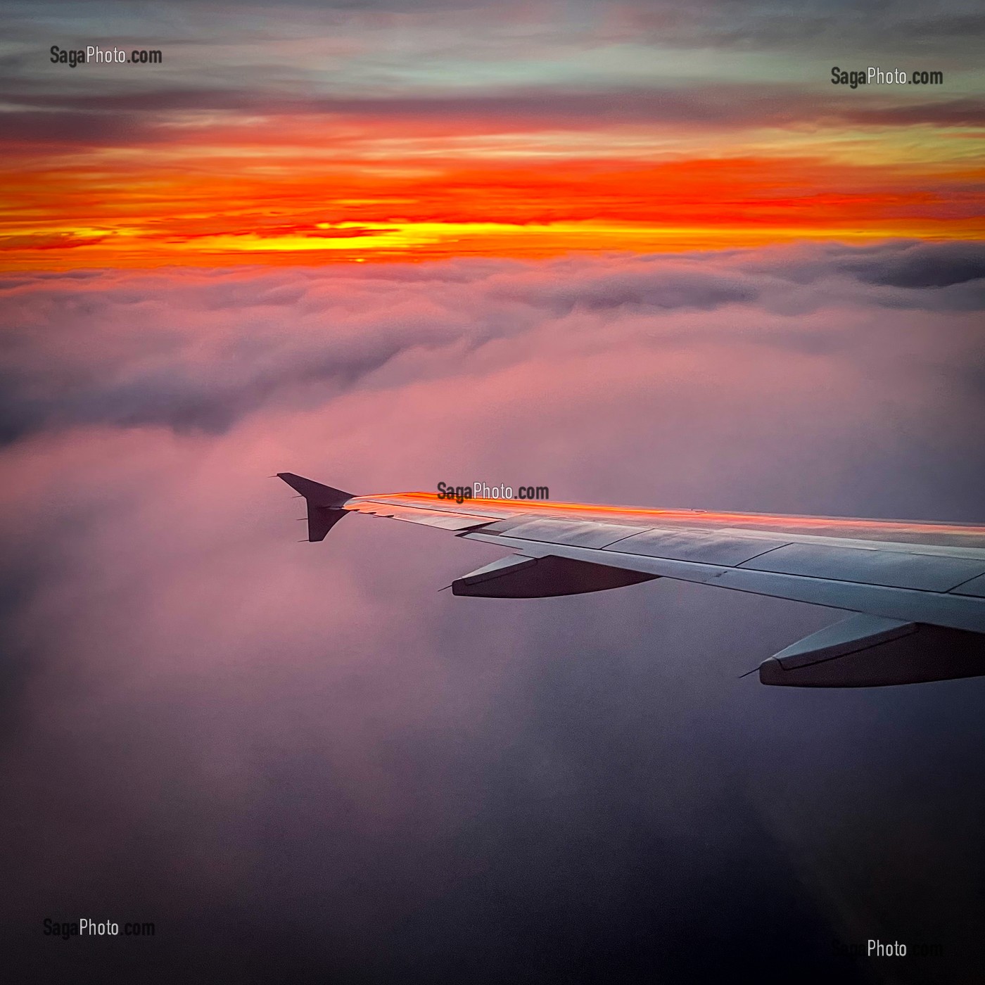 AILE D'AVION AU COUCHER DU JOUR SUR LES NUAGES 