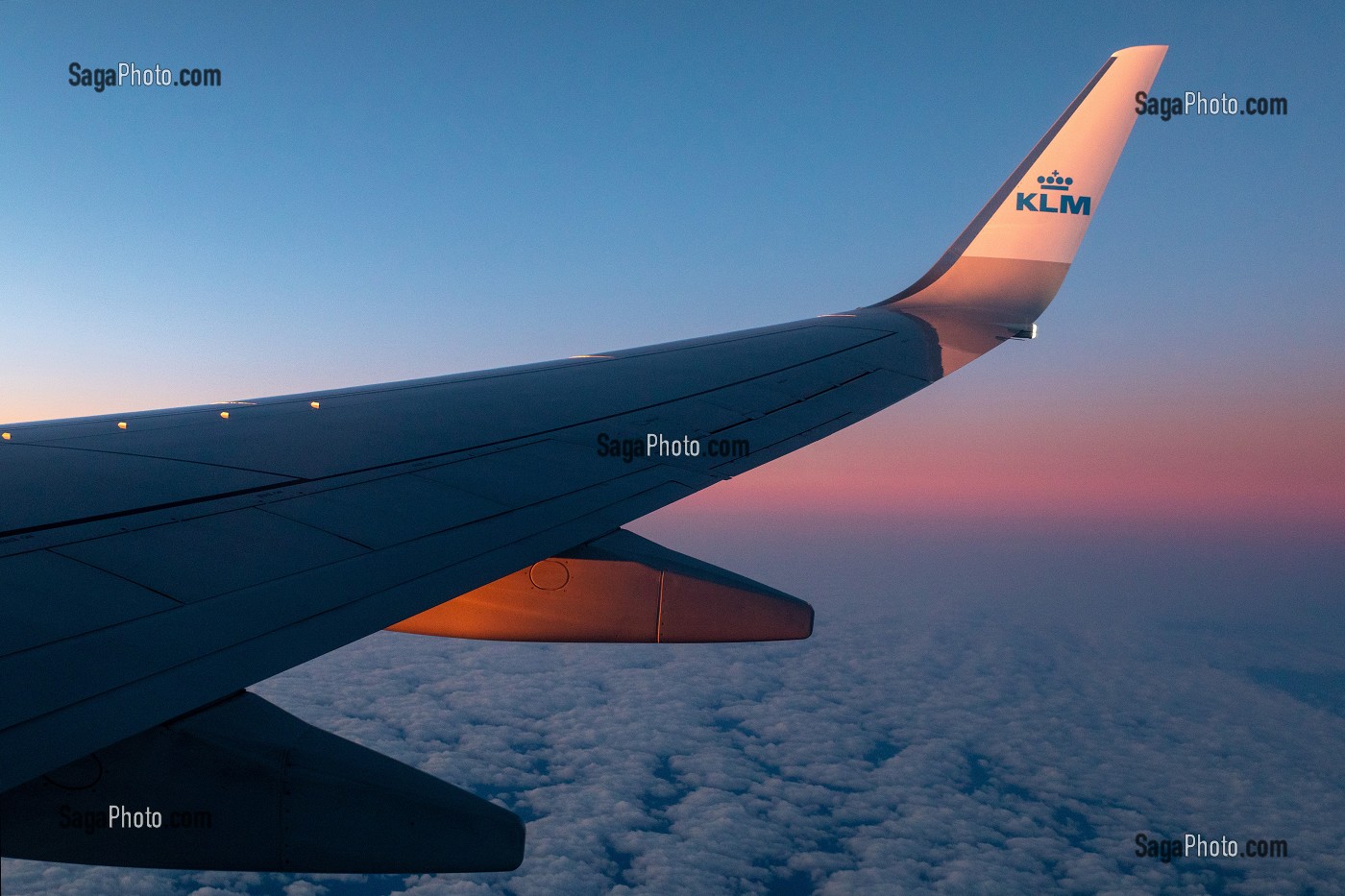 AILE D'AVION DE LA COMPAGNIE AERIENNE KLM AU COUCHER DU JOUR SUR UN CIEL DE NUAGES 