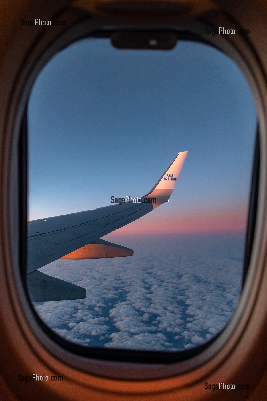 AILE D'AVION DE LA COMPAGNIE AERIENNE KLM AU COUCHER DU JOUR SUR UN CIEL DE NUAGES 