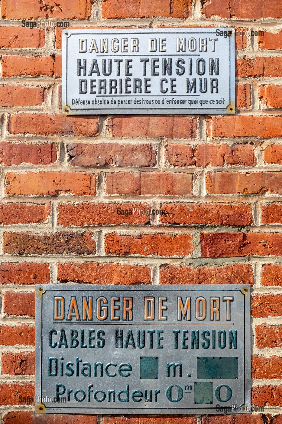 PLAQUE DE PREVENTION POUR RISQUES DE DANGER DE MORT AVEC DES CABLES A HAUTE TENSION DERRIERE LE MUR DE BRIQUE 