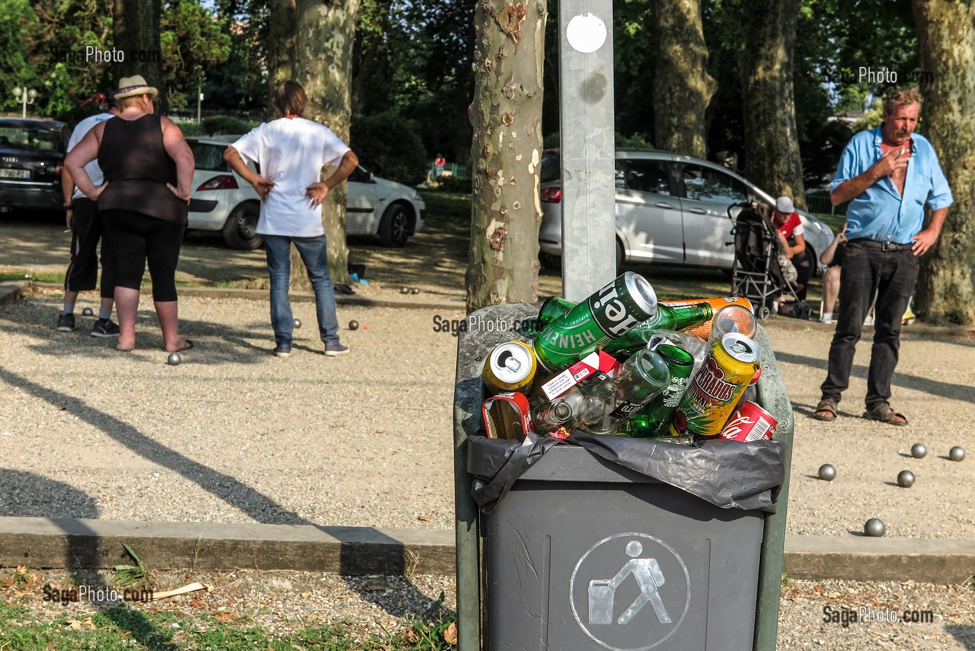 SCENE DE RUE, POUBELLE PLEIN DE BOUTEILLES DE BIERE PAQUETS DE CIGARETTES DEVANT LE TERRAIN DE BOULES, BLAYE, GIRONDE, FRANCE 