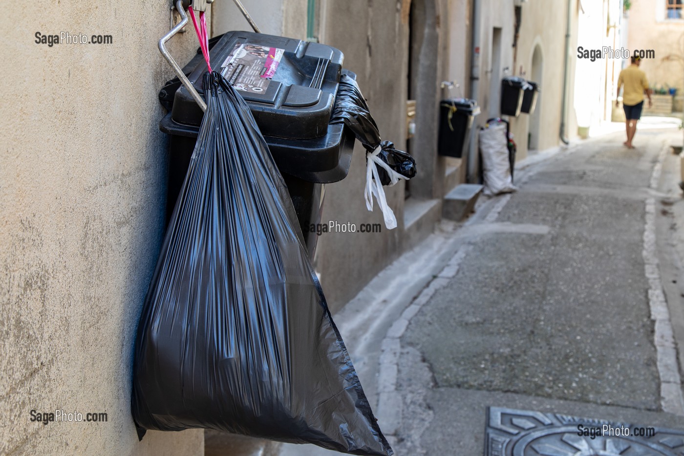 POUBELLES ACCROCHEES AUX MURS DANS LES RUES, ANIANE, HERAULT, OCCITANIE, FRANCE 