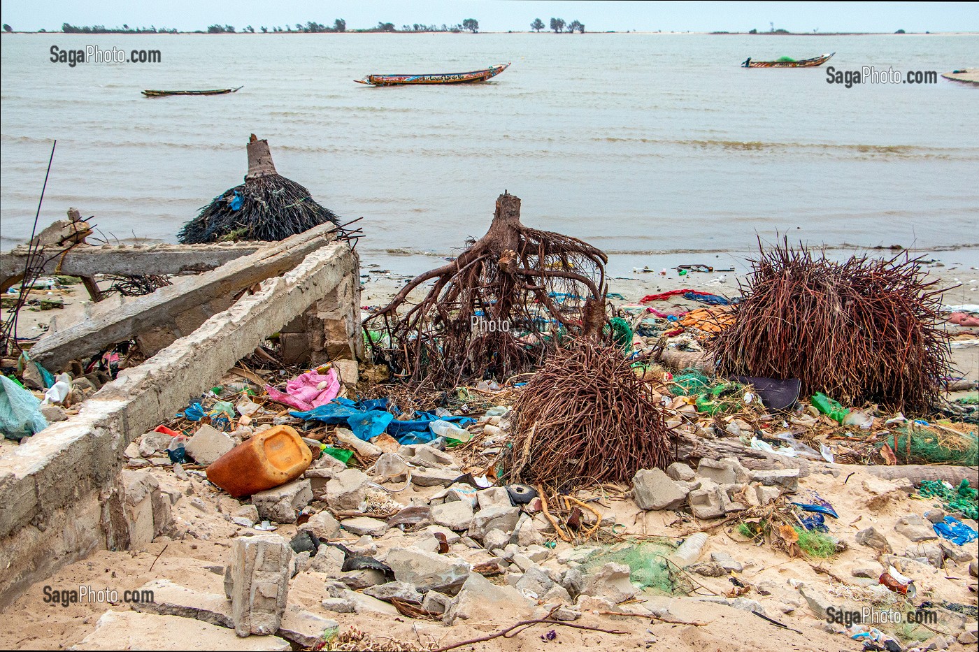 MONTEE DES EAUX SALEES SUR LES PLAGES DE LA LAGUNE DU FLEUVE DETRUISANT MAISONS ET ARBRES (RACINES DE COCOTIERS) AU MILIEU DES DECHETS PLASTIQUES, SAINT-LOUIS-DU-SENEGAL, SENEGAL, AFRIQUE DE L'OUEST 