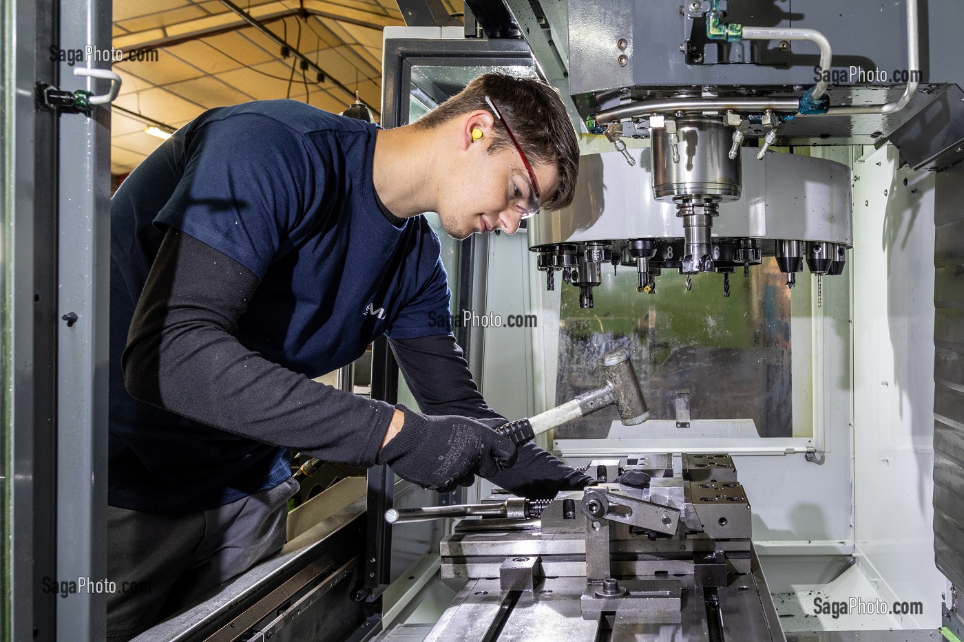 OUVRIER QUI INSTALLE UN PIECE SUR SA MACHINE, USINAGE DE PIECES METALLIQUE, SMA, SOCIETE MECANIQUE AIGLONNE, INDUSTRIE METALLURGIQUE, SAINT-MARTIN-D'ECUBLEI, ORNE, NORMANDIE, FRANCE 